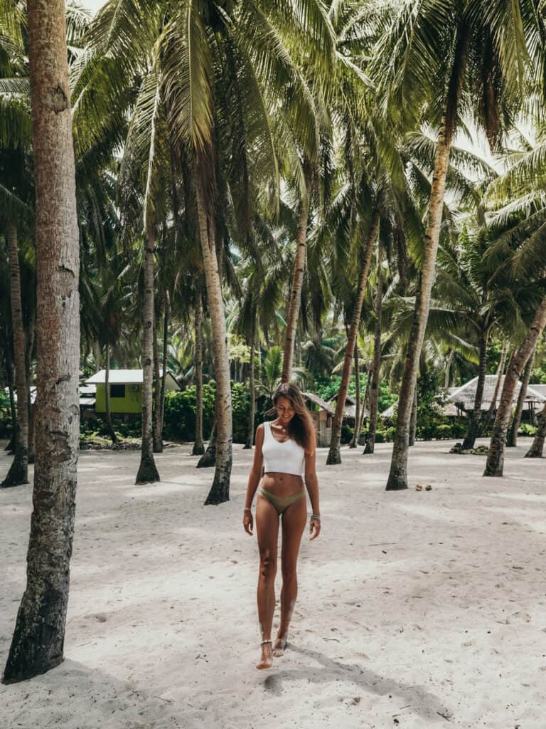 Women walking between palm trees on Daku Island Siargao