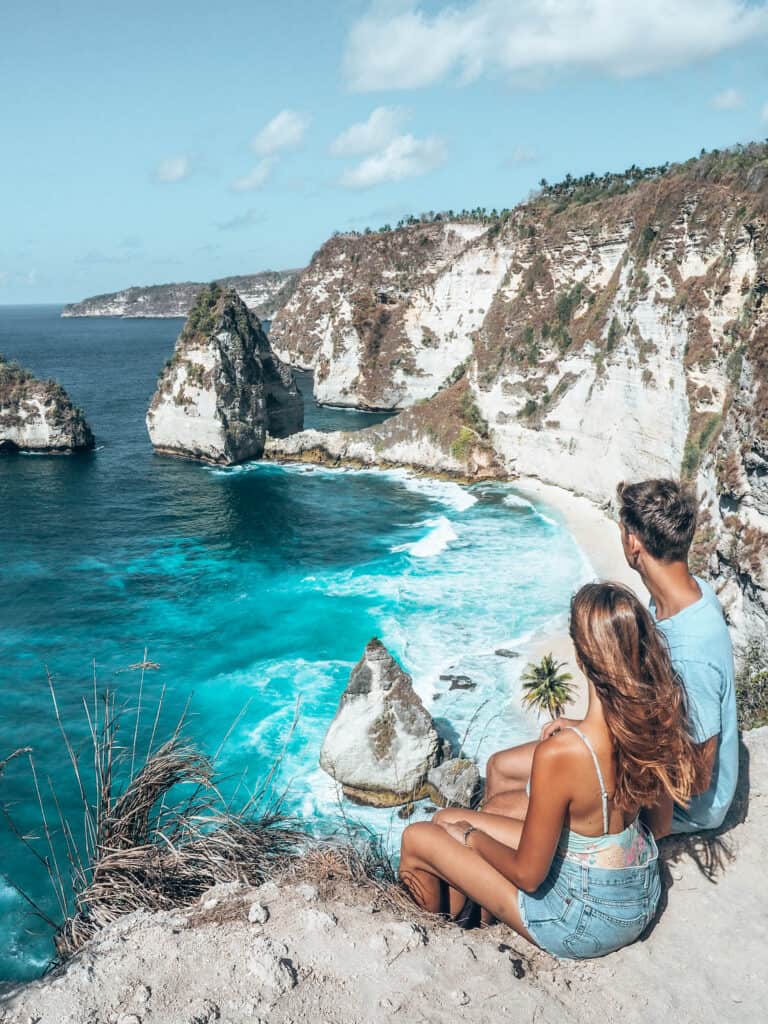 Couple sitting on cliff of Diamond Beach Nusa Penida