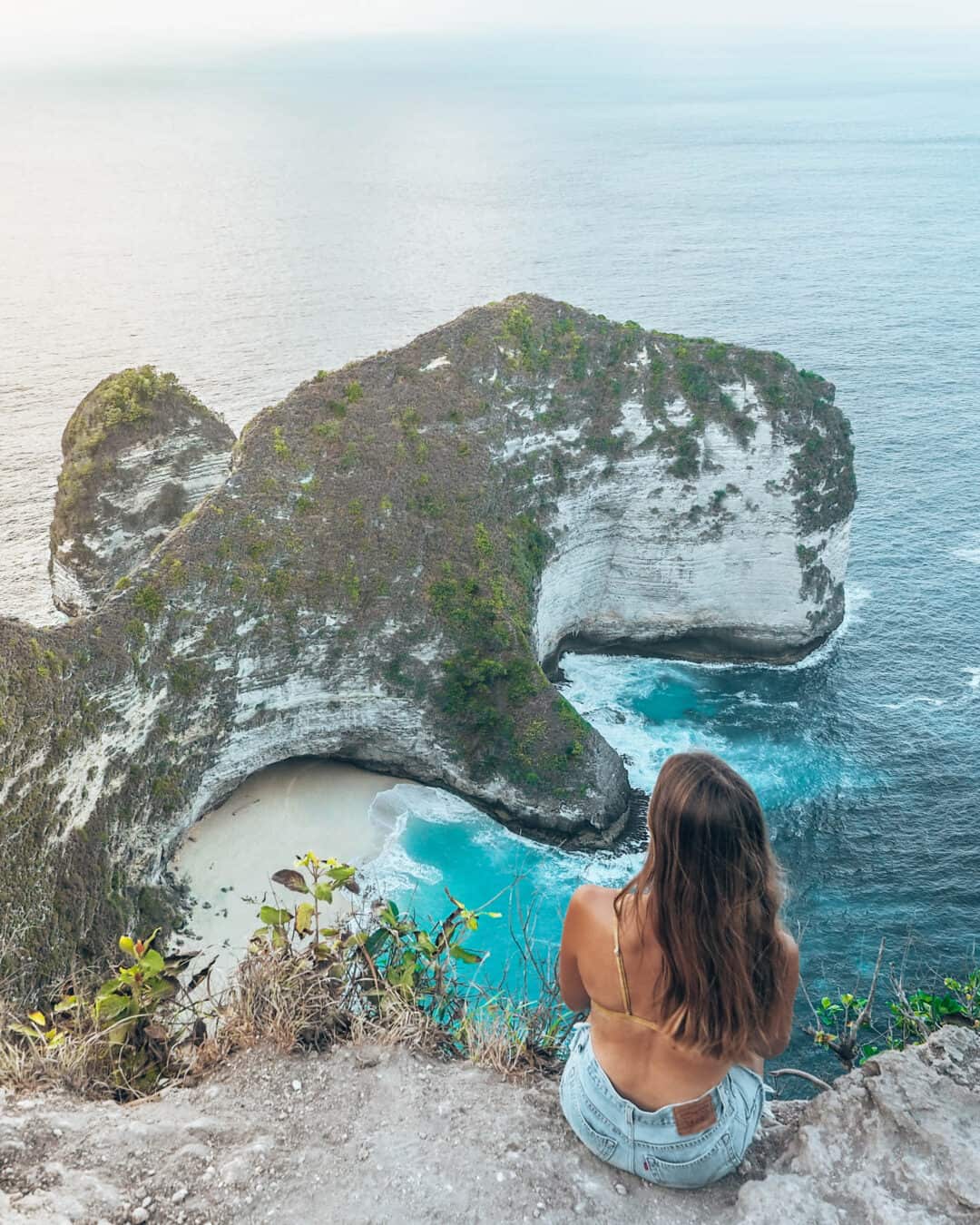 Women sitting on the cliff of Kelinking Beach Nusa Penida