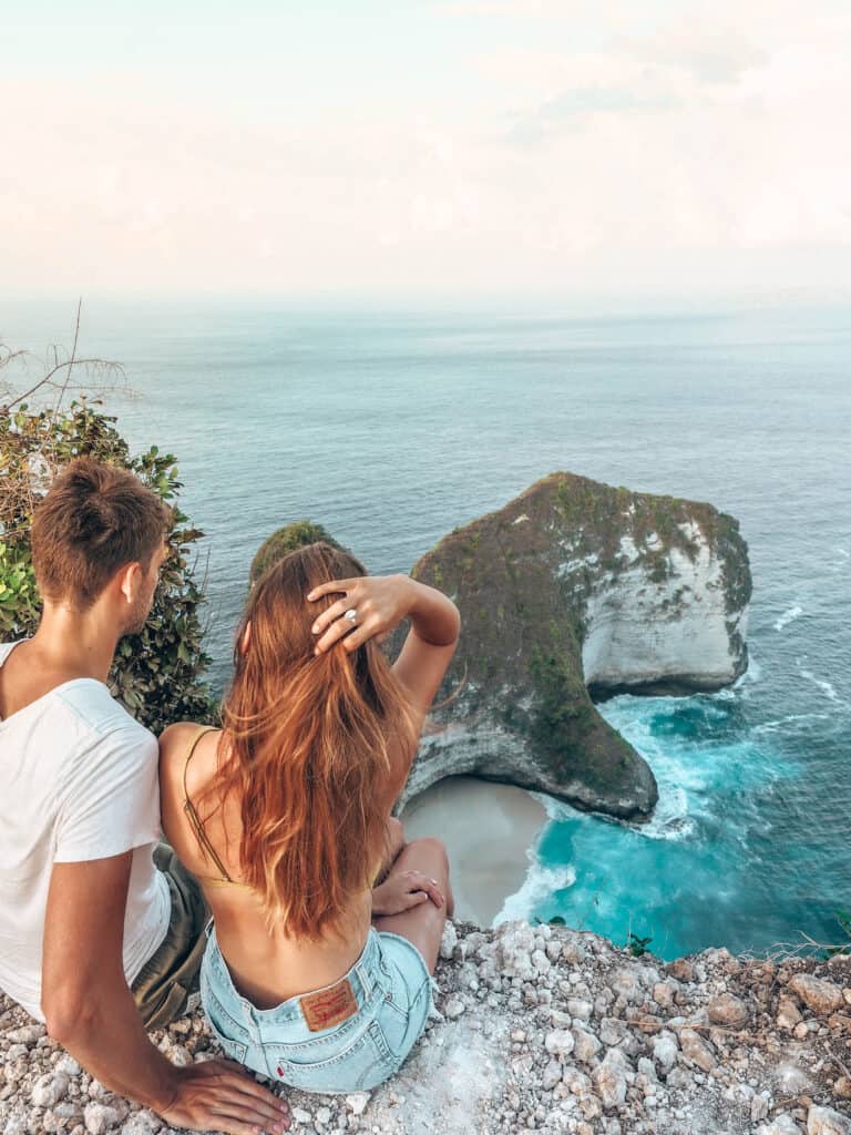 Couple sitting on the cliff of Kelinking Beach Nusa Penida