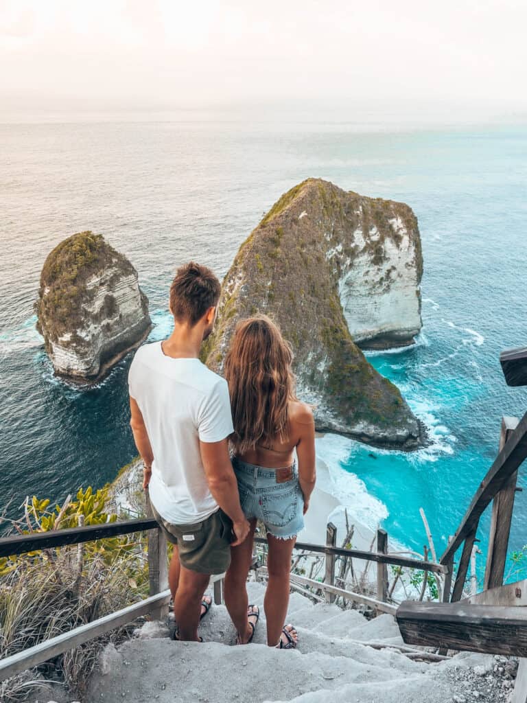 Couple walking stairs down to Kelinking Beach Nusa Penida