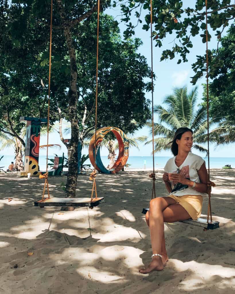 Women sitting on swing with coffee at Lio Beach El Nido Philippines