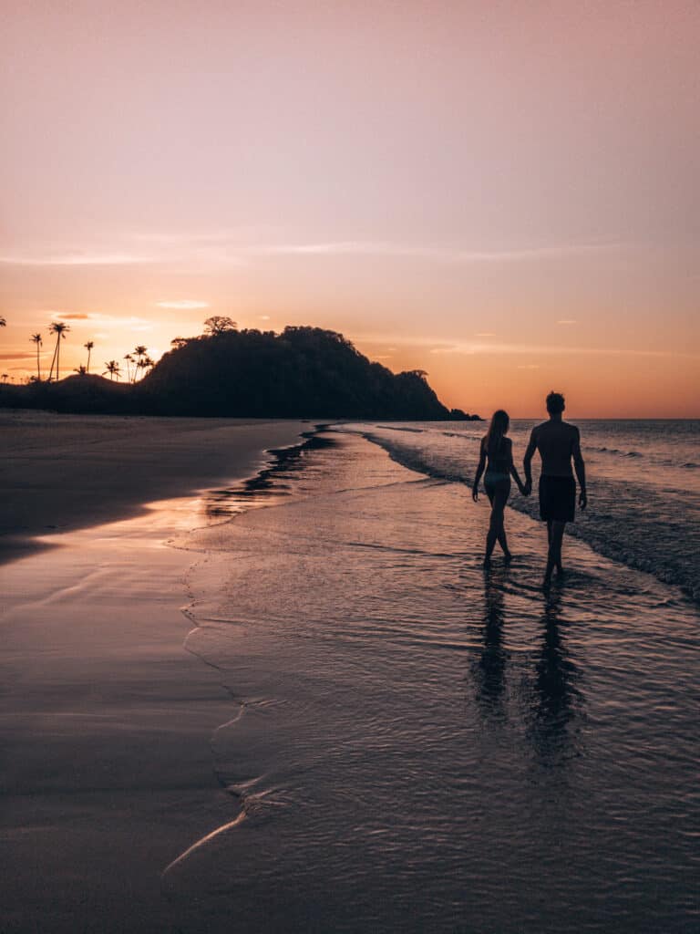 Couple walking on Nacpan Beach on Sunset El Nido Philippines