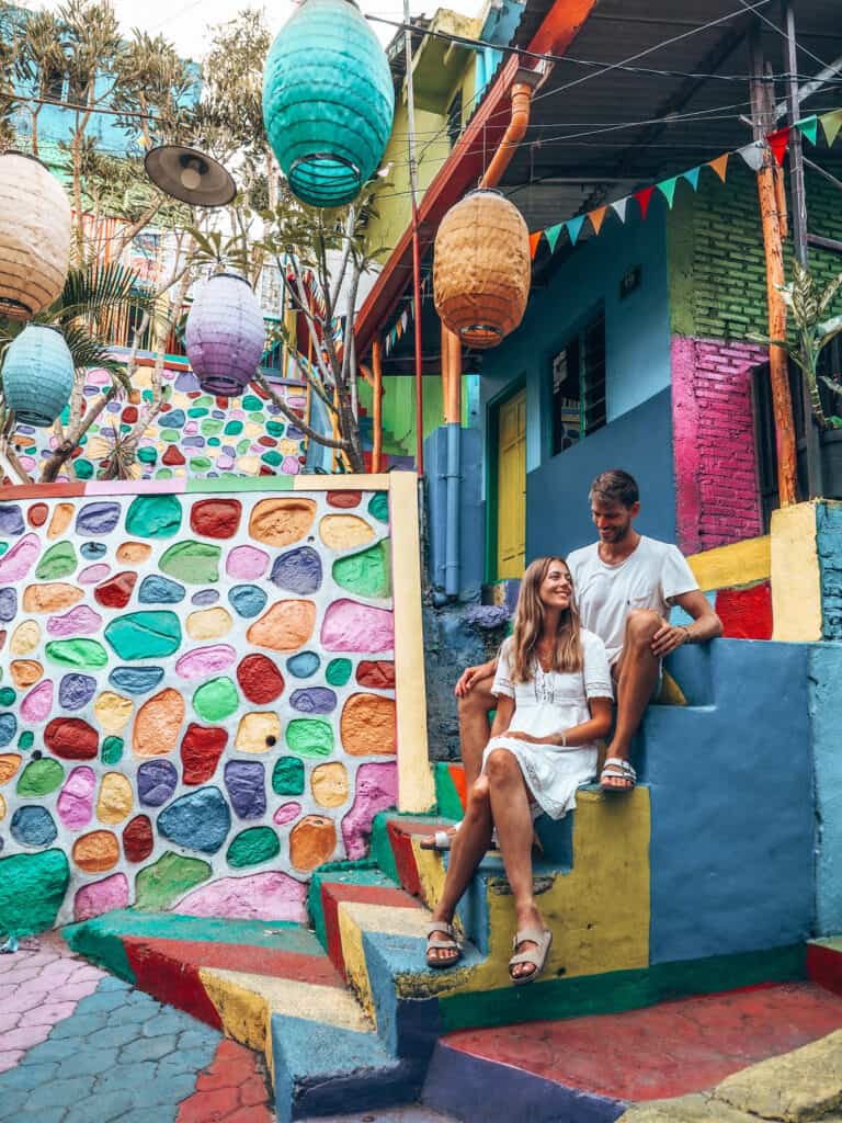 Couple sitting on stairs at Rainbow Village Malang