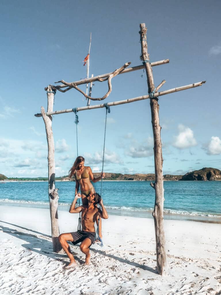 Couple on swing at Tanjung Aan Beach Lombok