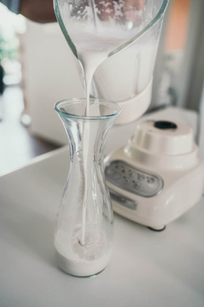 Filling a carafe with mixed nut milk