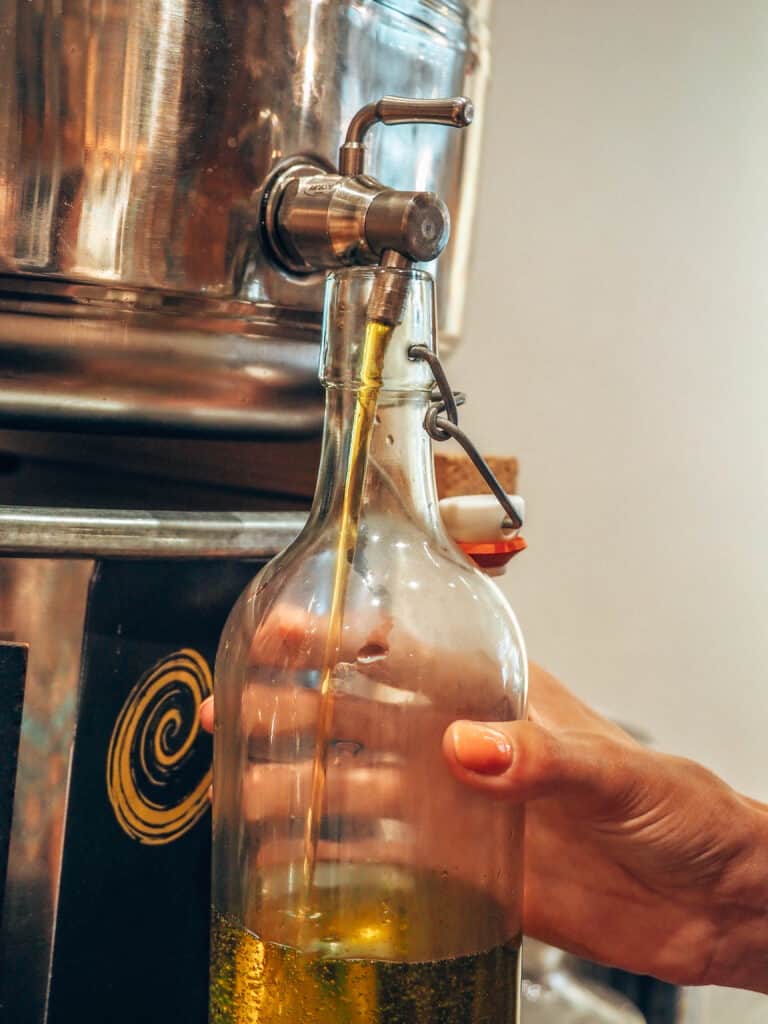 Filling a bottle of glas with olive oil