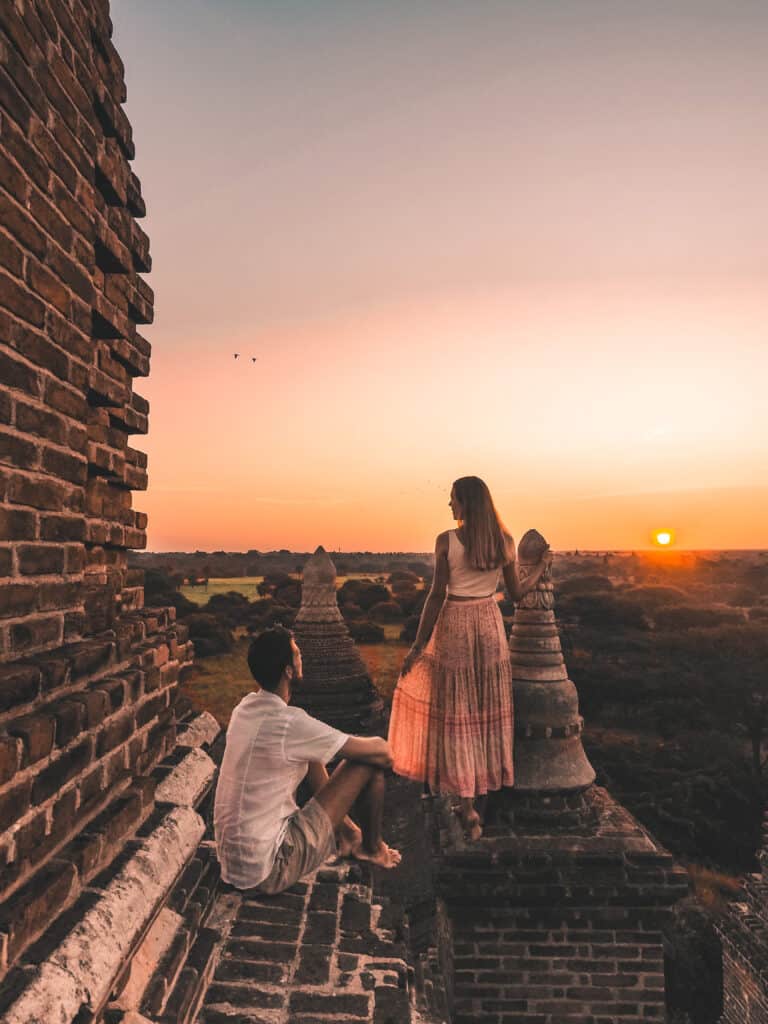 Couple on rooftop of Pagoda at sunset in Bagan Myanmar