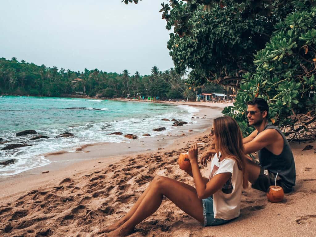 Hiriketiya Beach Couple drinking coconuts