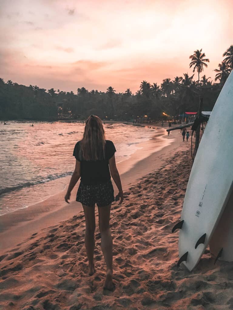 Hiriketiya Beach sunset women walking surfboards