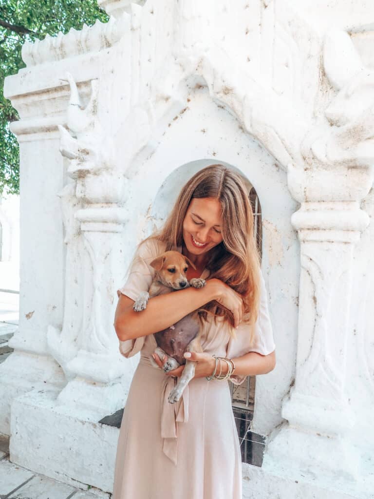 Women holds a young dog in her arms at Kuthodaw Pagoda Mandalay