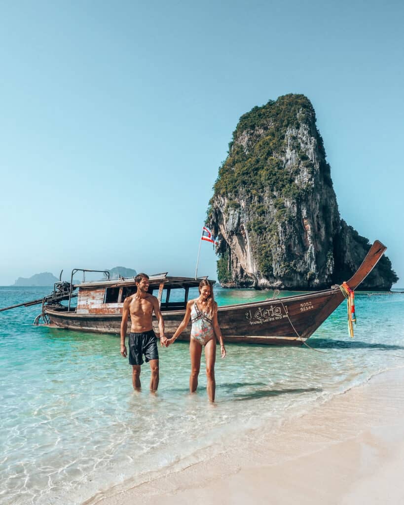 Couple in front of longtail boat at phra nang beach