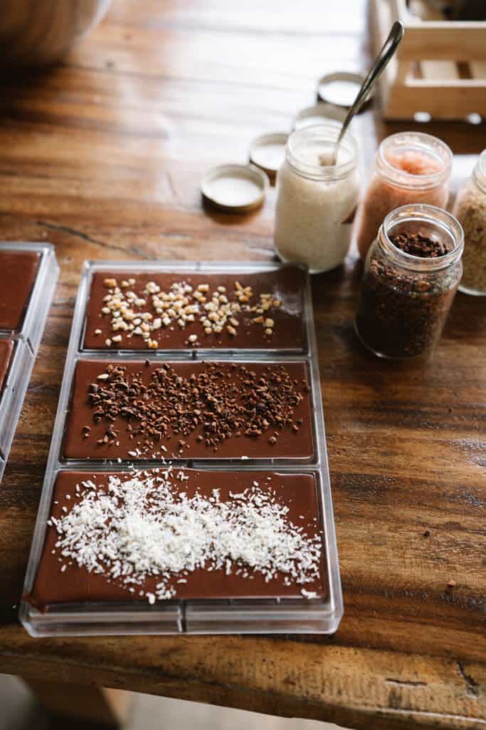 Raw and liquid chocolate in a mold with different toppings