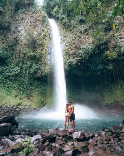 Couple standing in front of La Fortuna Waterfall Costa Rica