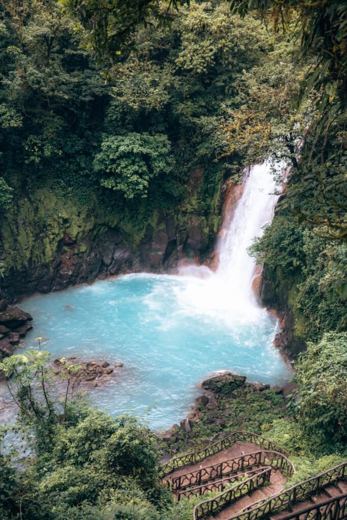 A waterfall in the middle of a lush green forest.