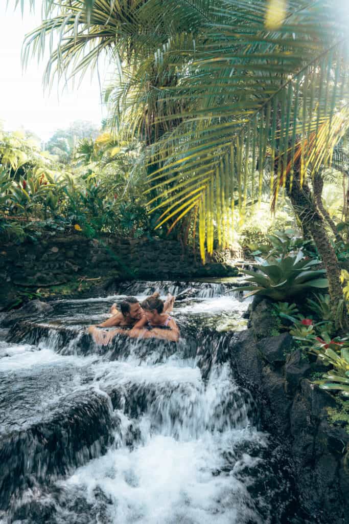 A man and woman relaxing in a waterfall.