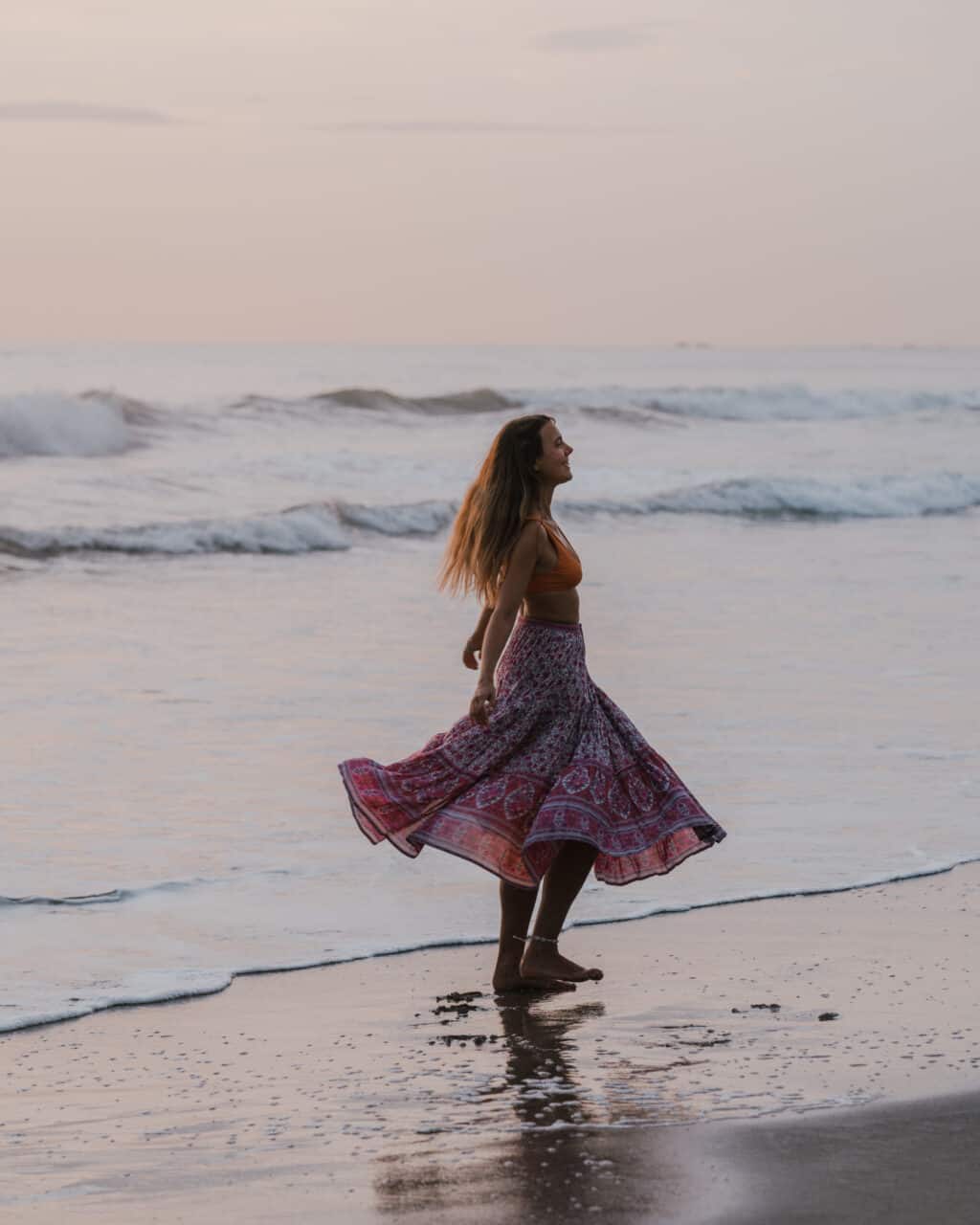 Woman dancing at the beach with sustainable clothing