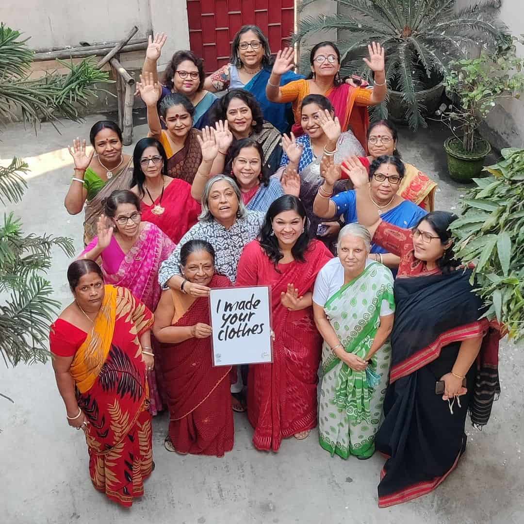 A group of women in sustainable saris posing for a photo.