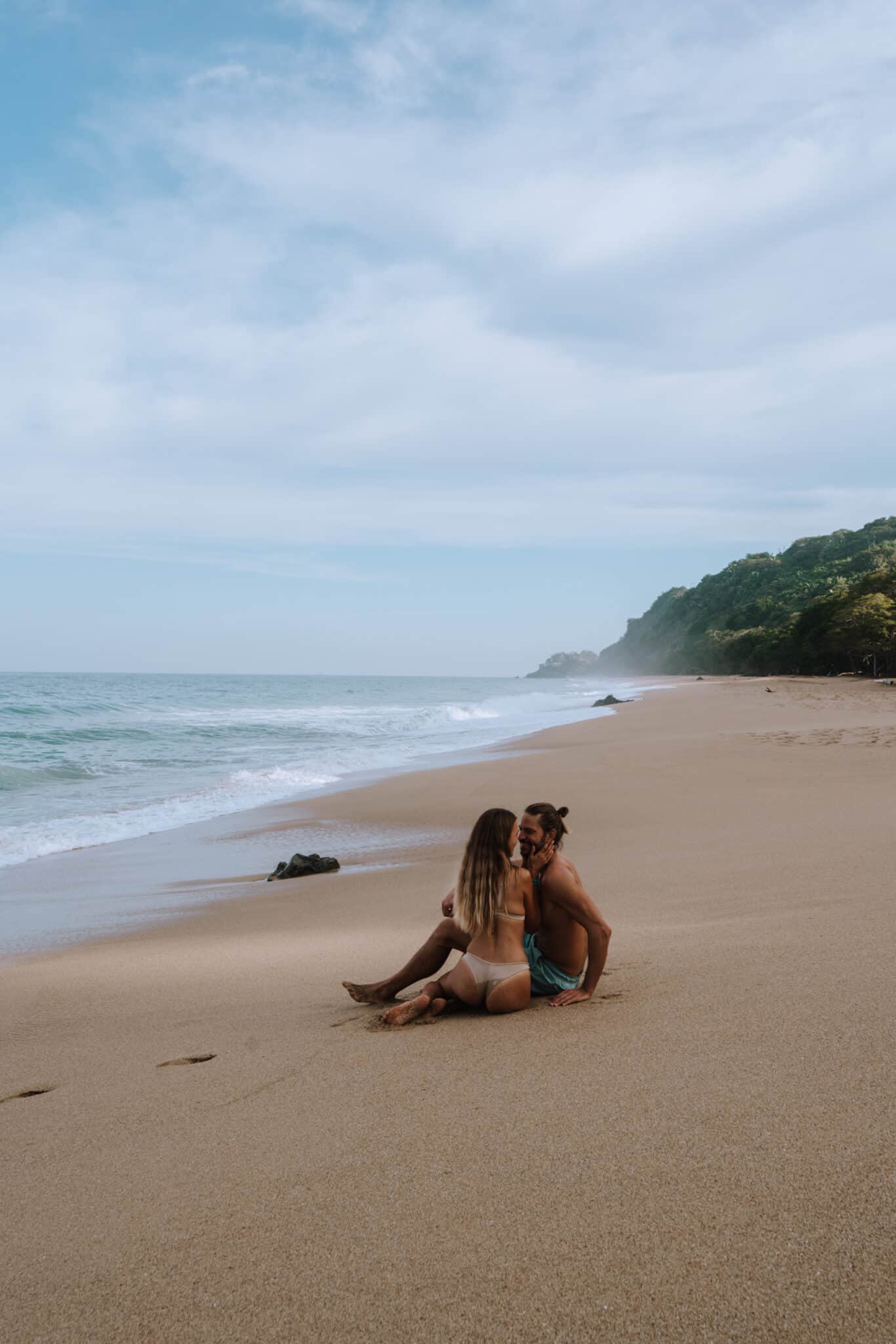 Two people sitting on a beach in Sayulita, Costa Rica.