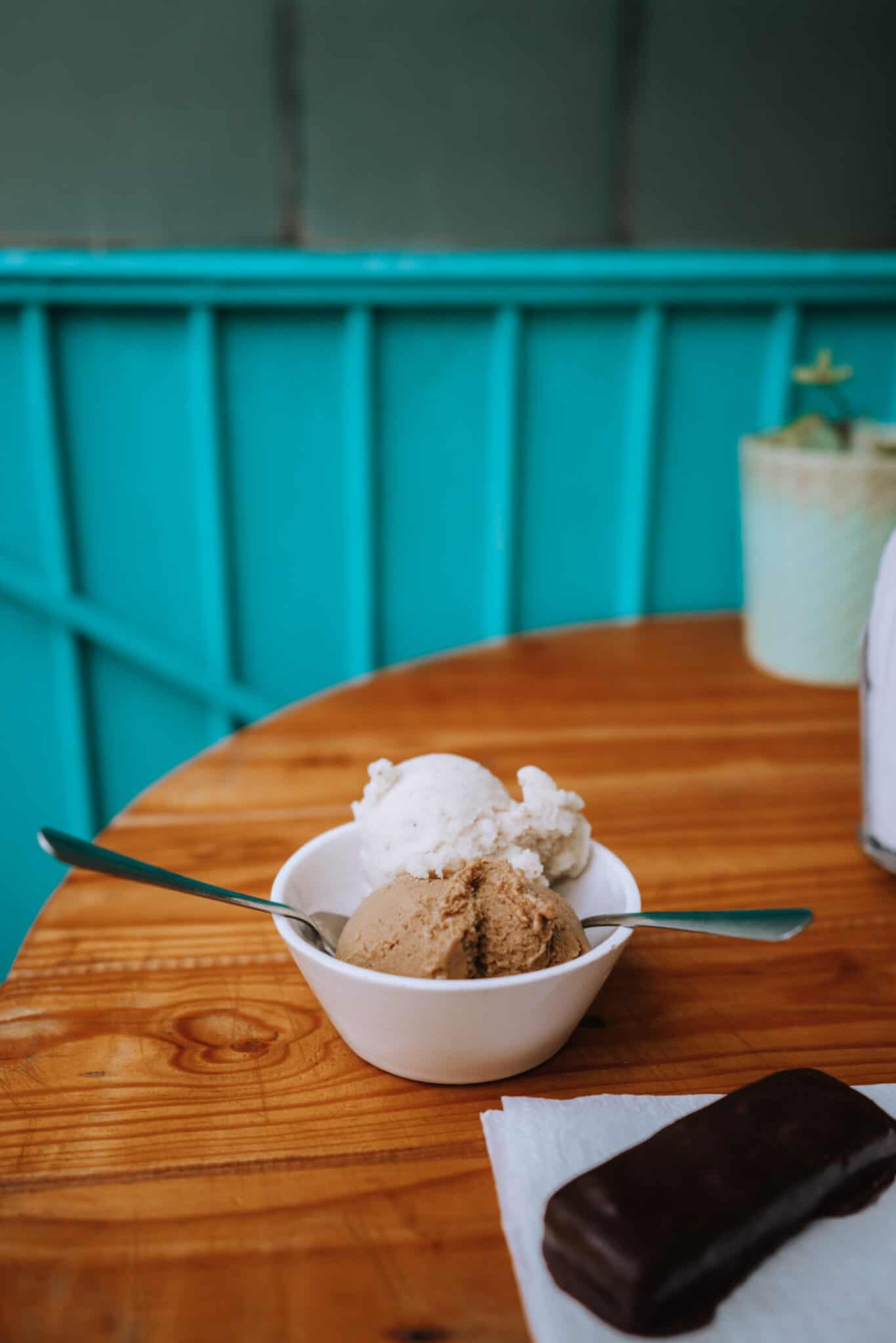 A bowl of ice cream and a chocolate bar on a wooden table in Sayulita.