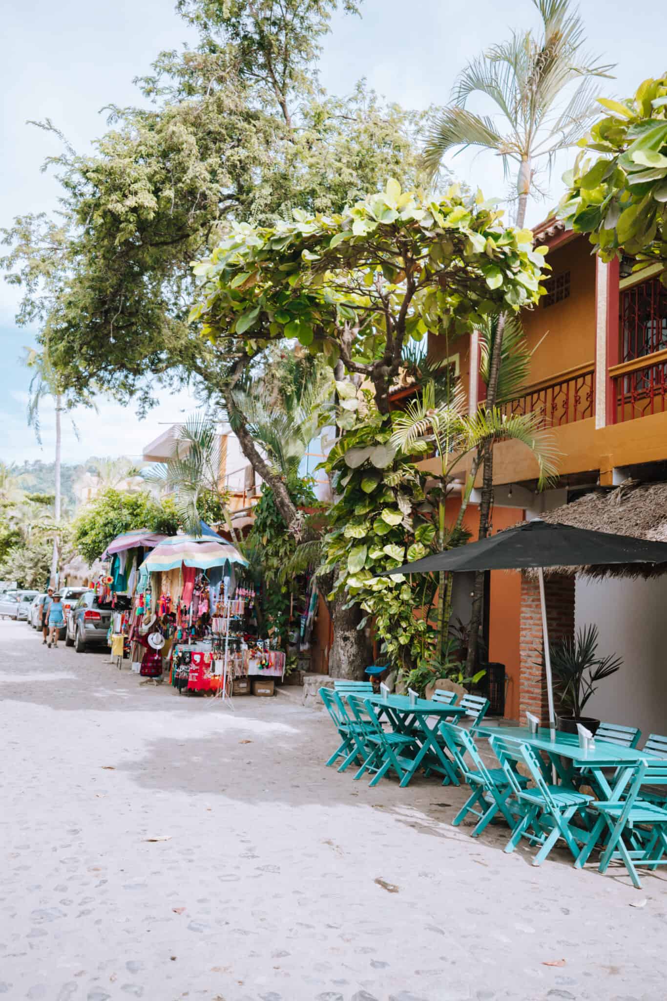 A row of tables and chairs on a street in Sayulita, Costa Rica.