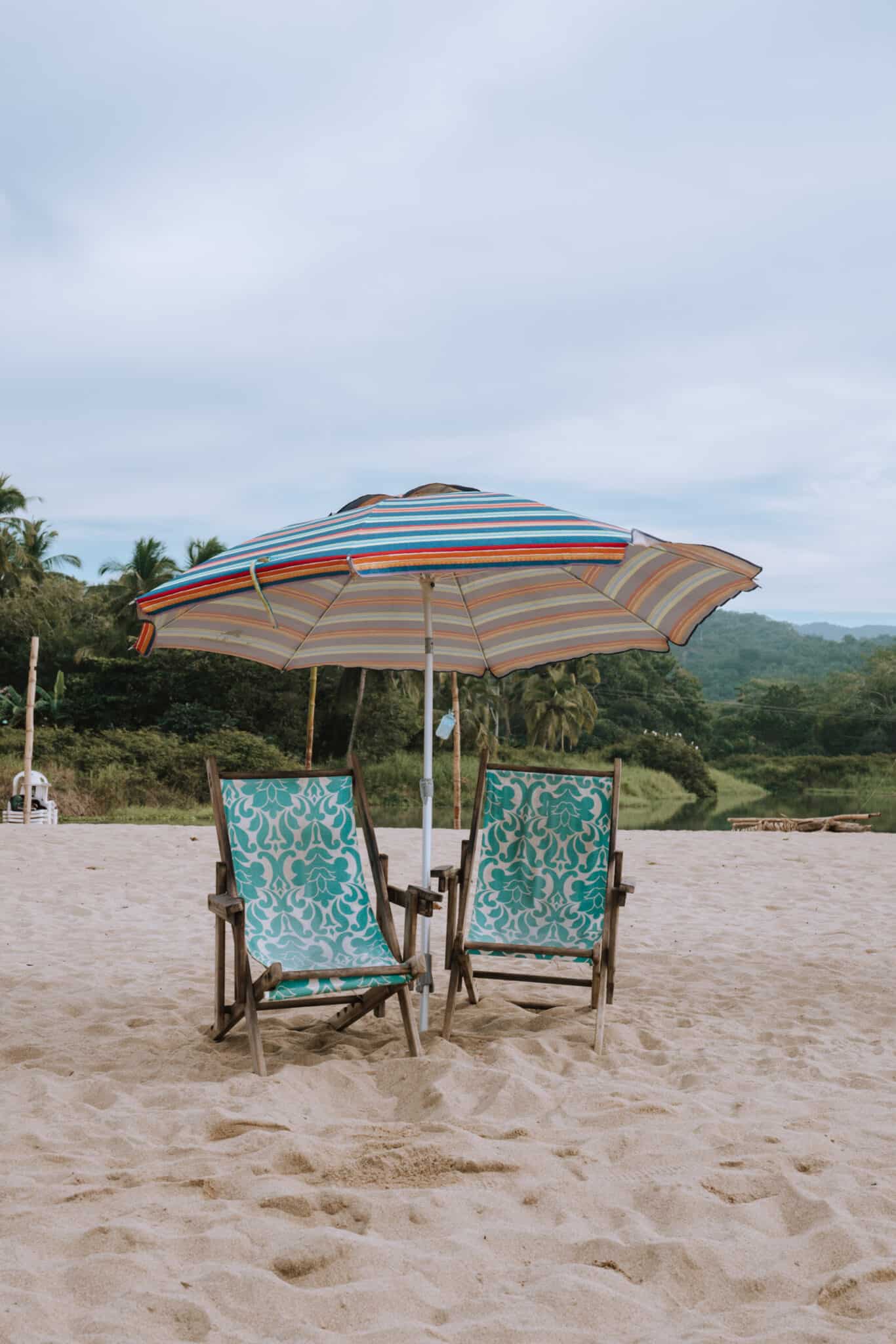 Two chairs on the Sayulita beach under an umbrella.