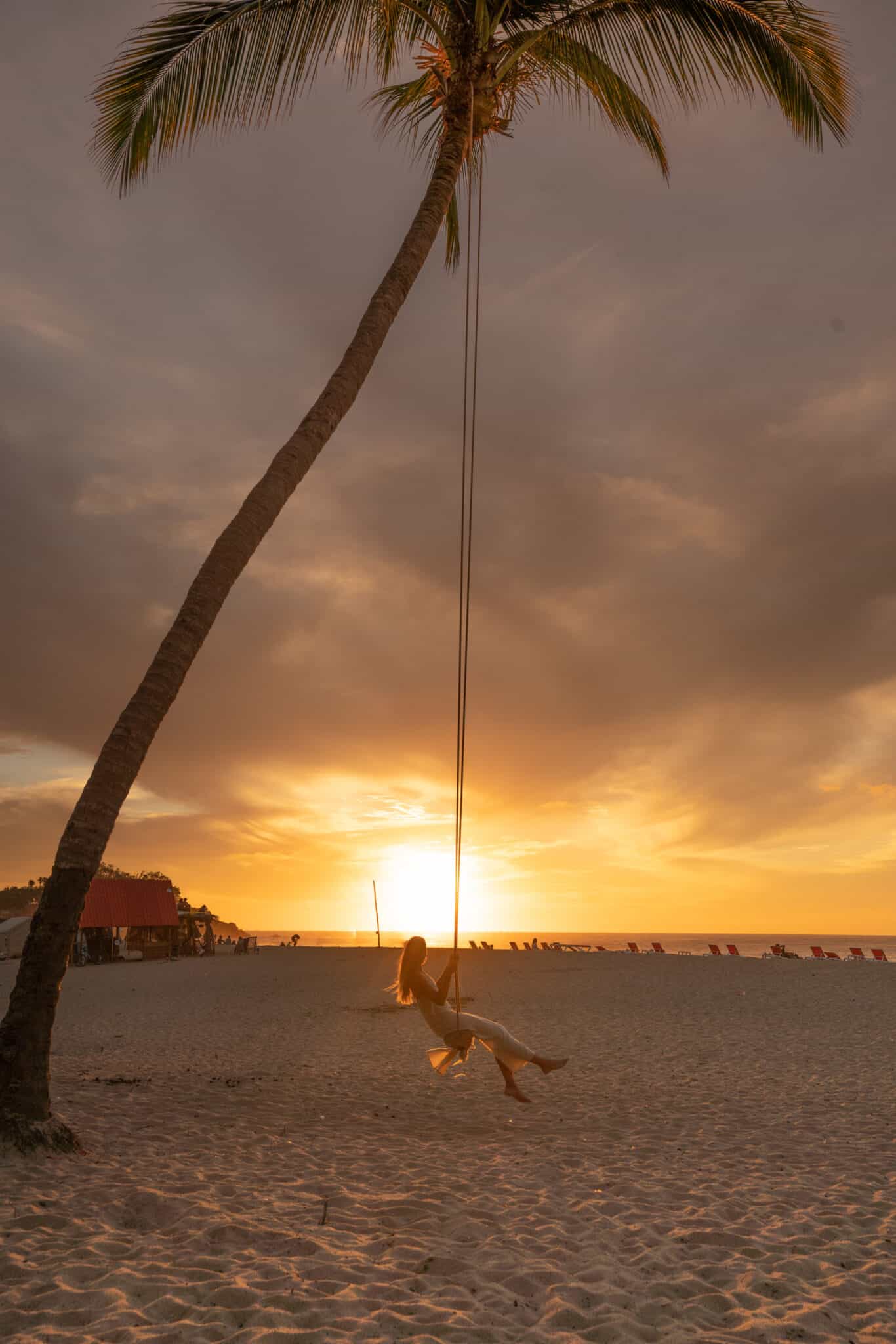 A woman swinging on a swing at Sayulita beach.