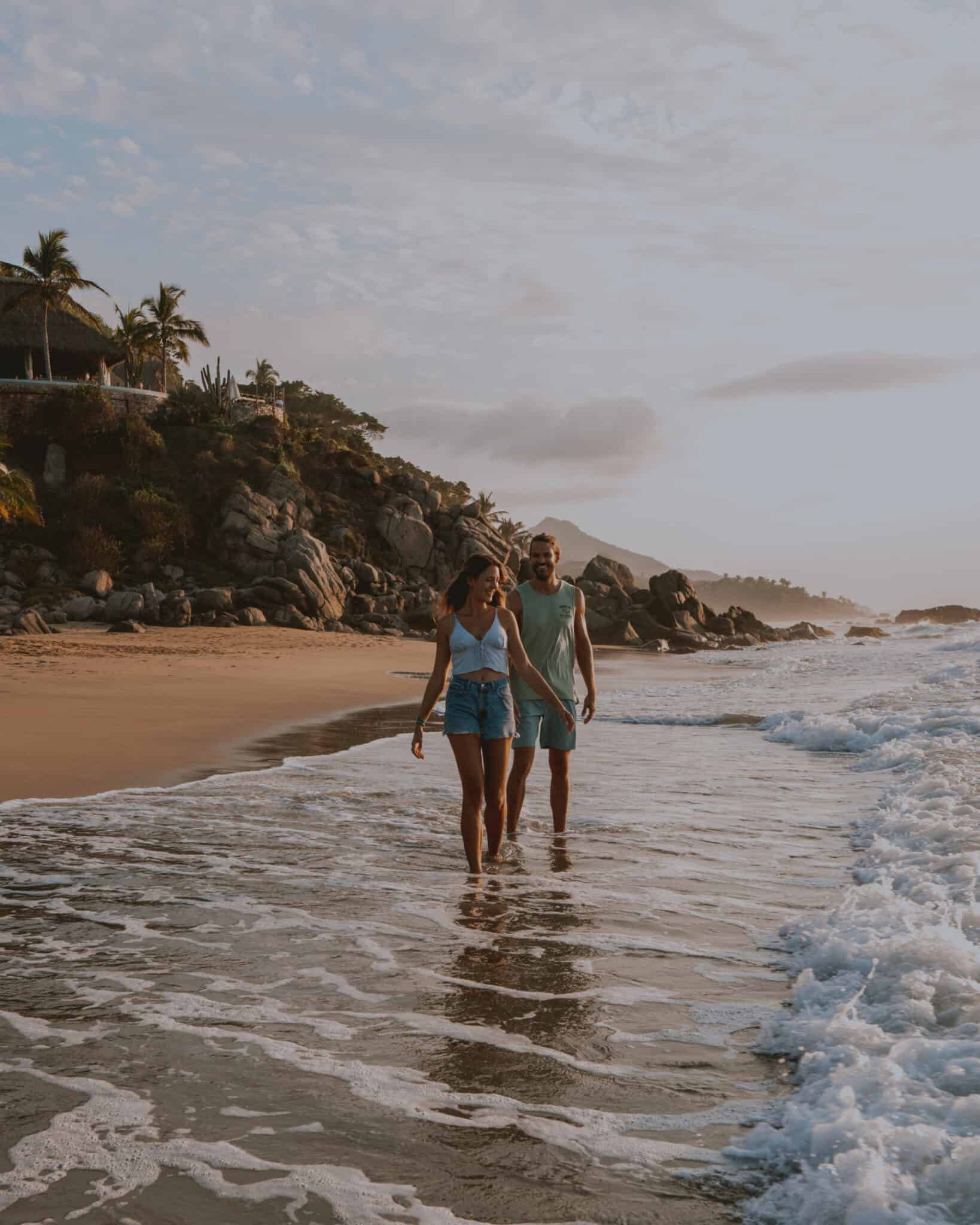 A couple walking on the Sayulita beach at sunset.