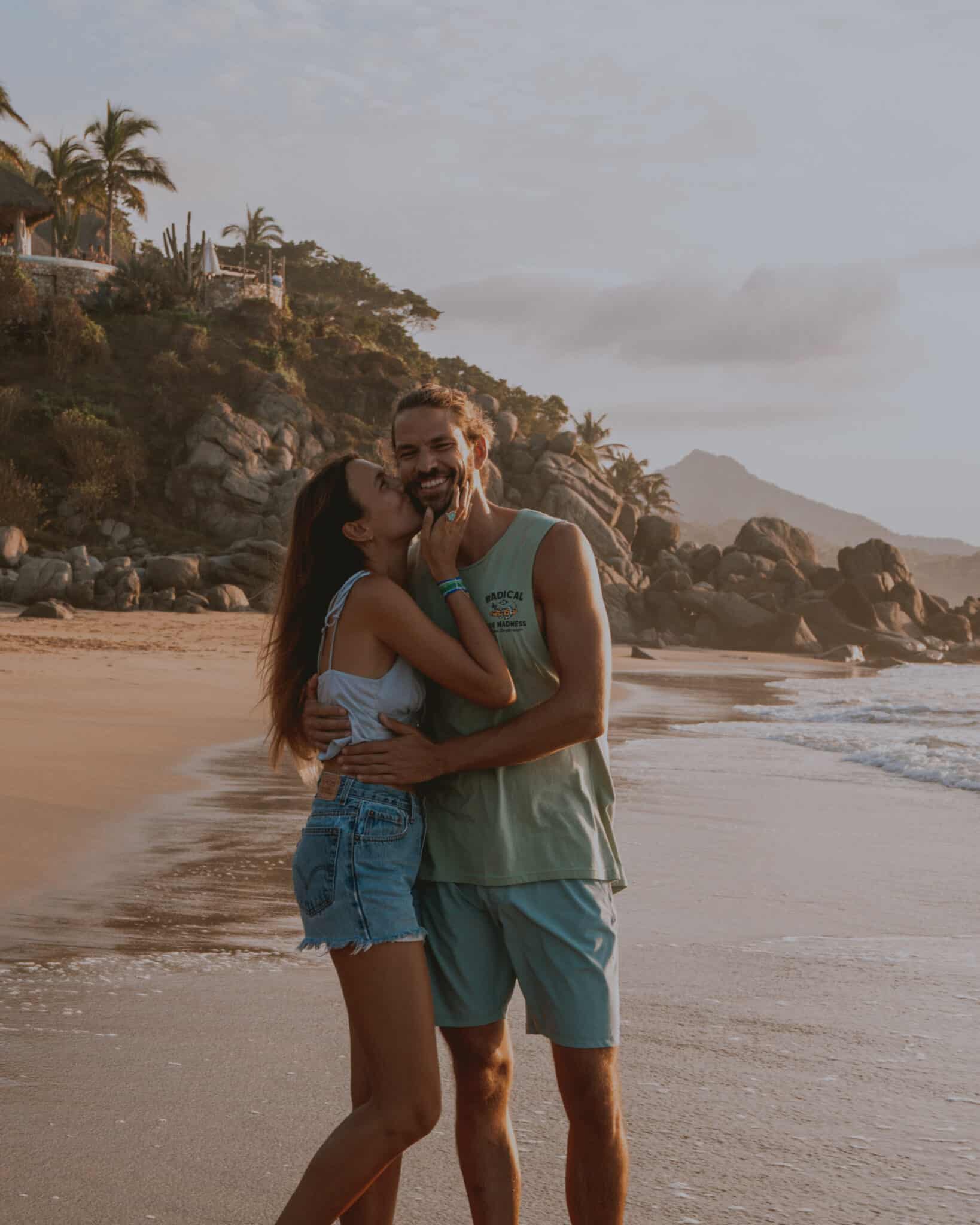 A couple kissing on Sayulita beach at sunset.