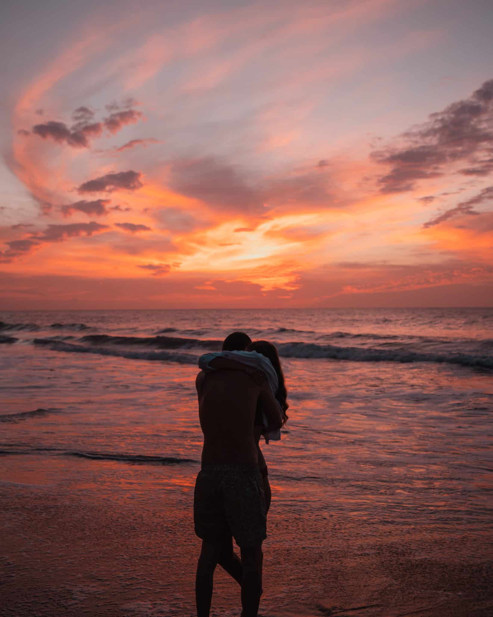 A couple hugging on the Sayulita beach at sunset.