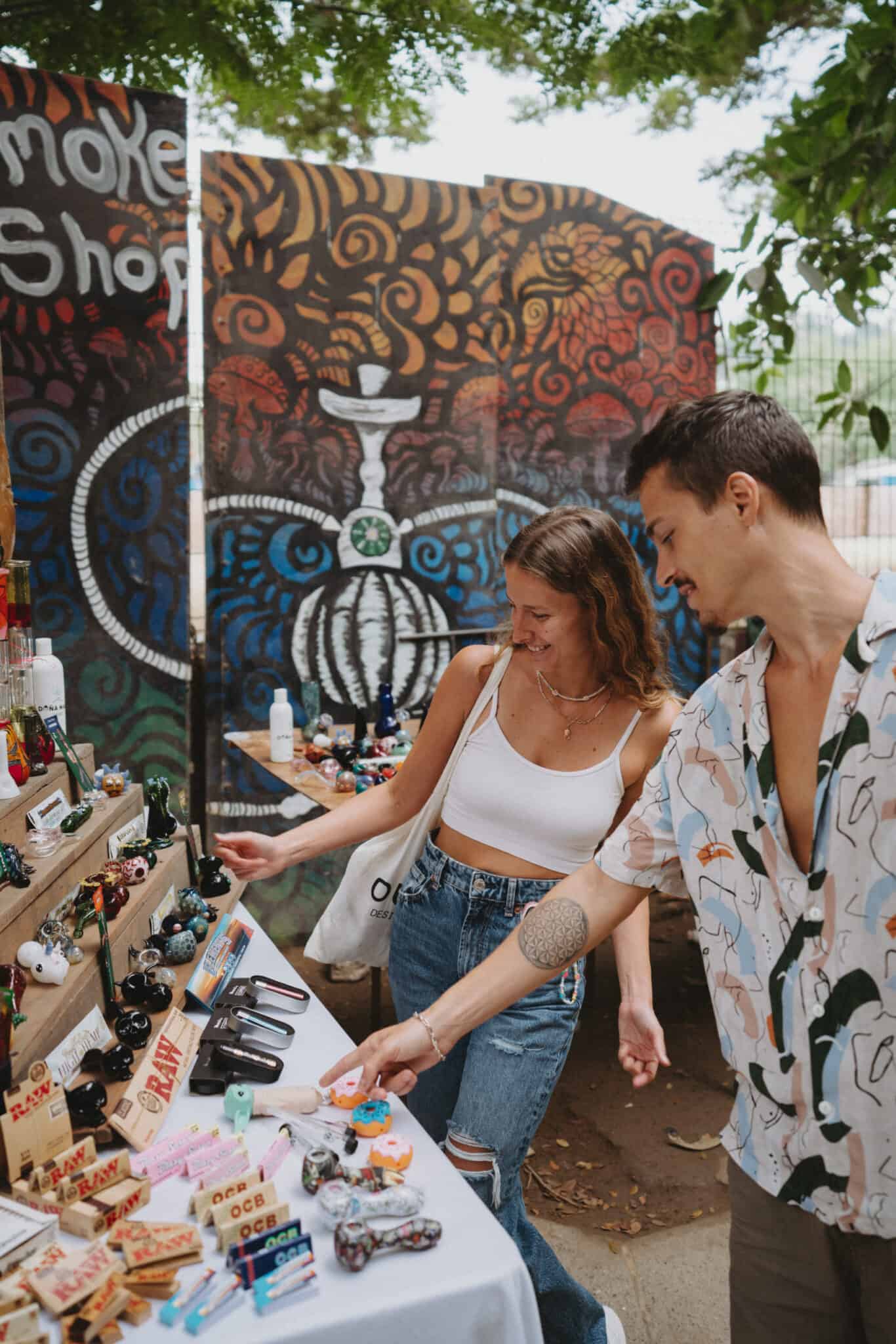 A man and woman in Sayulita looking at a table full of marijuana products.