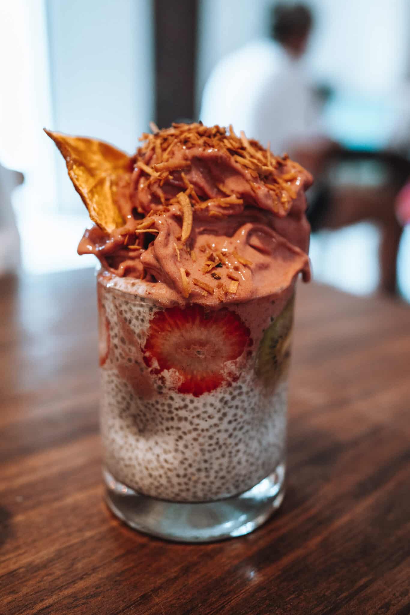 A cup of chia pudding on a wooden table in Sayulita.