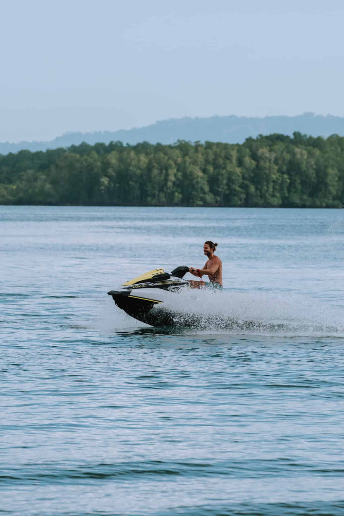 A man riding a jet ski on a lake, seeking employment opportunities.