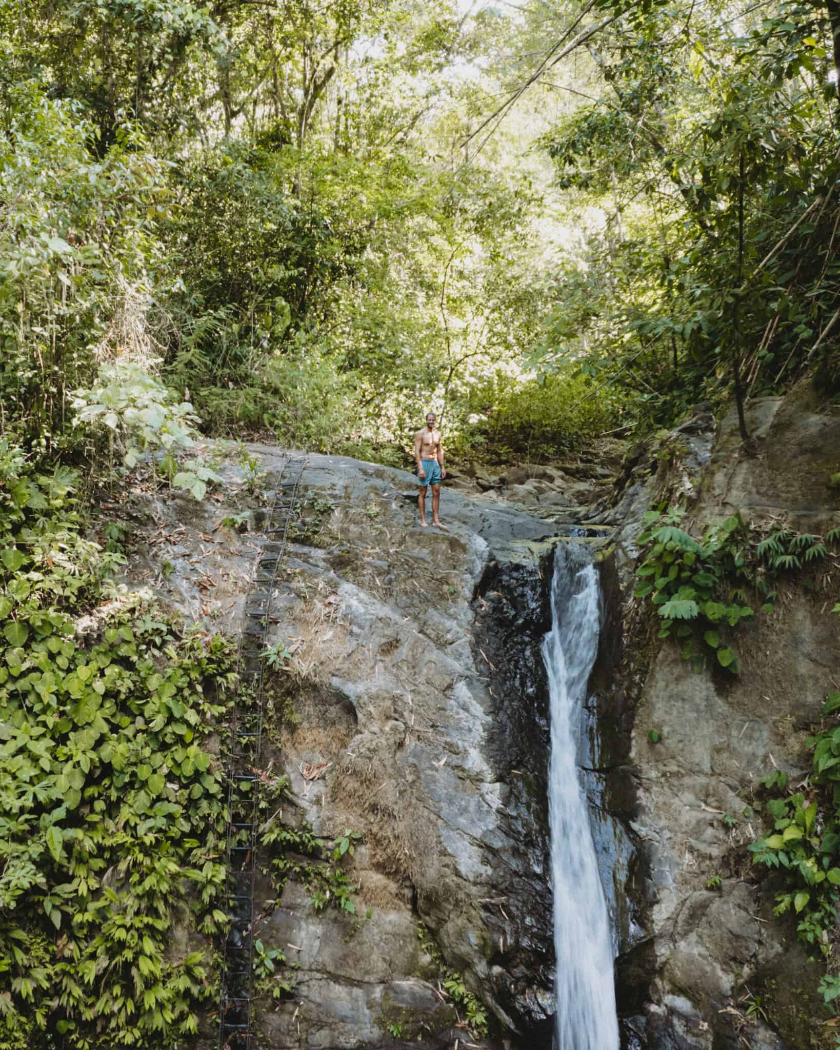 A woman standing next to a waterfall in Uvita, Costa Rica.