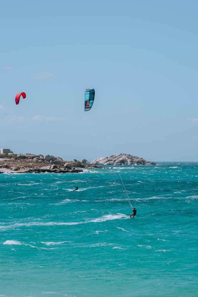 A group of people kitesurfing in the ocean off Naxos Island.