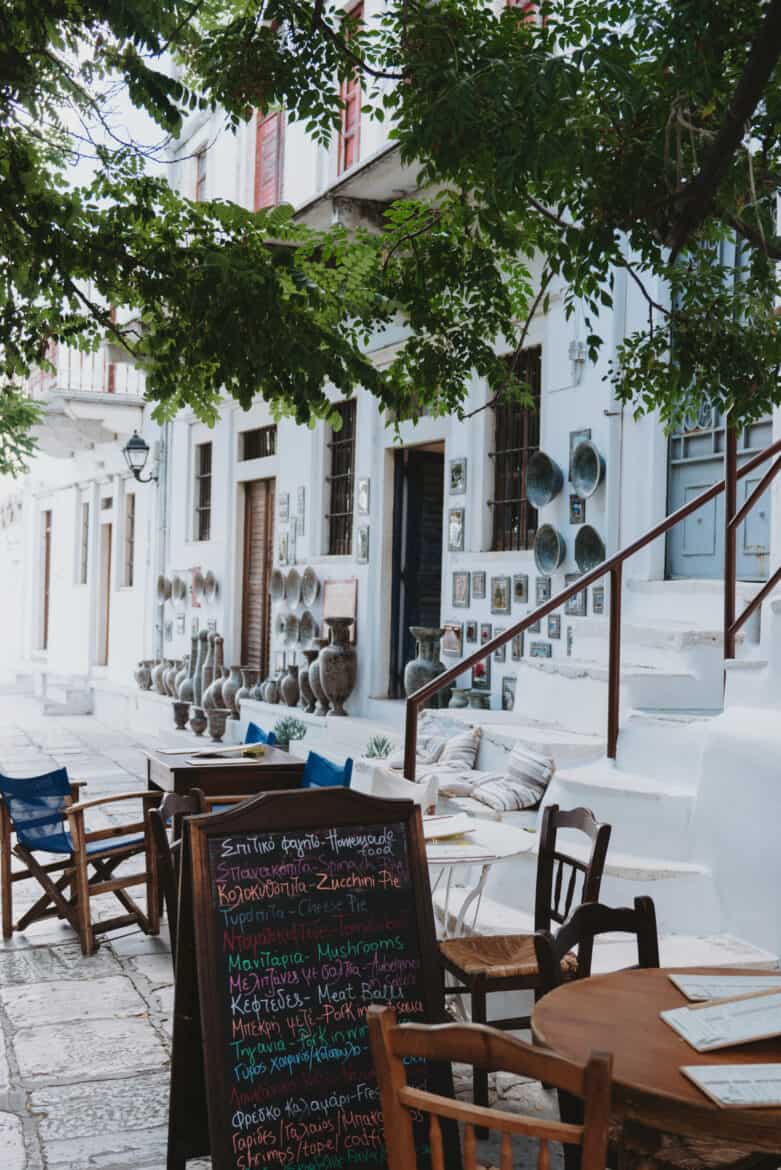 A white table with chairs and a sign on Naxos Island.