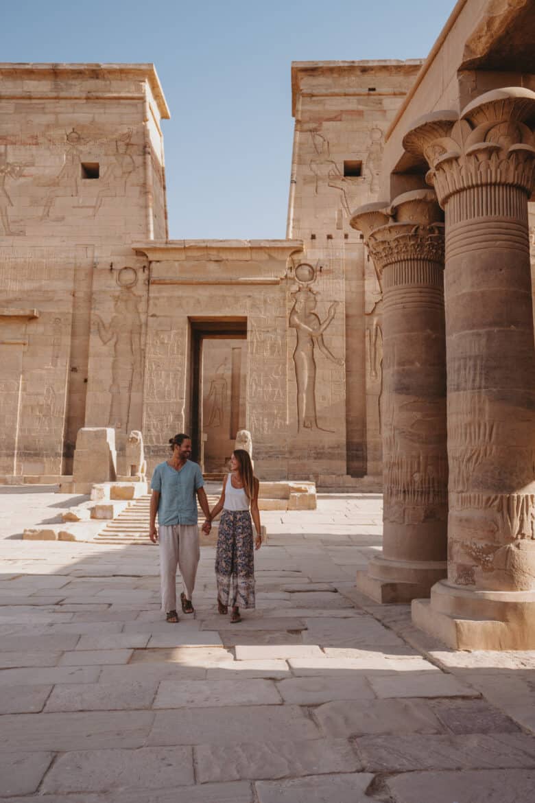 A couple exploring Egyptian temples during their trip.