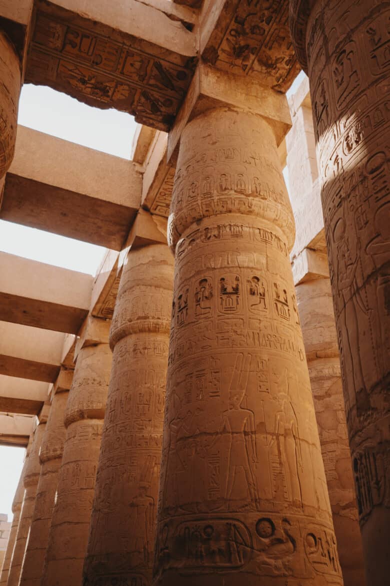 Egyptian pillars in Luxor, Egypt adorned with inscriptions.