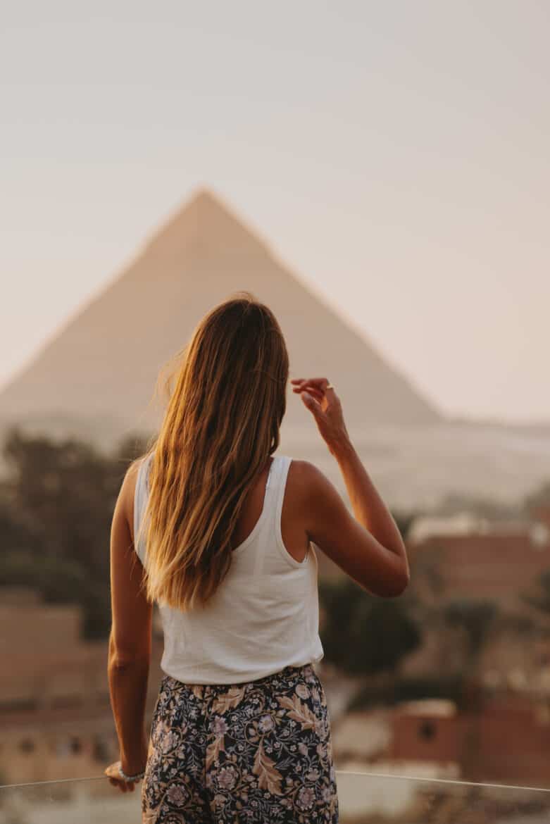 A woman admiring the iconic Pyramids of Giza.