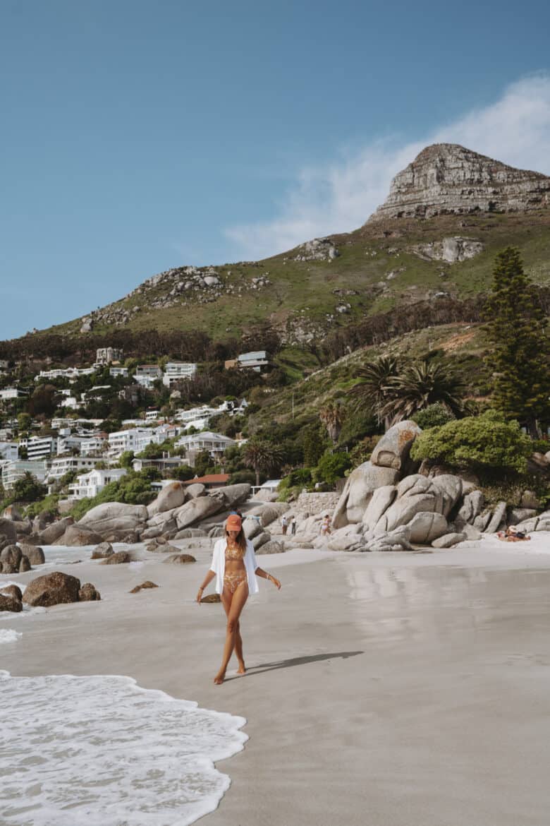 A woman in a bikini walking on the beach in cape town.