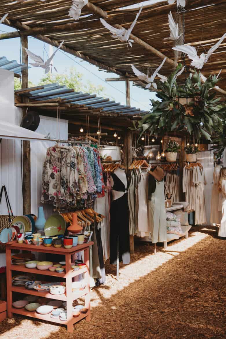 One of the best things to do in Cape Town, South Africa is visiting an outdoor market where clothes and birds hang from the ceiling.