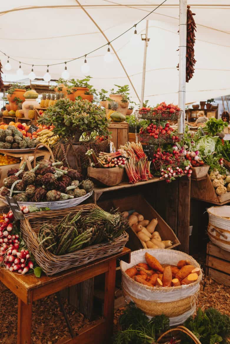 A farmer's market in Cape Town, South Africa with a variety of vegetables on display.