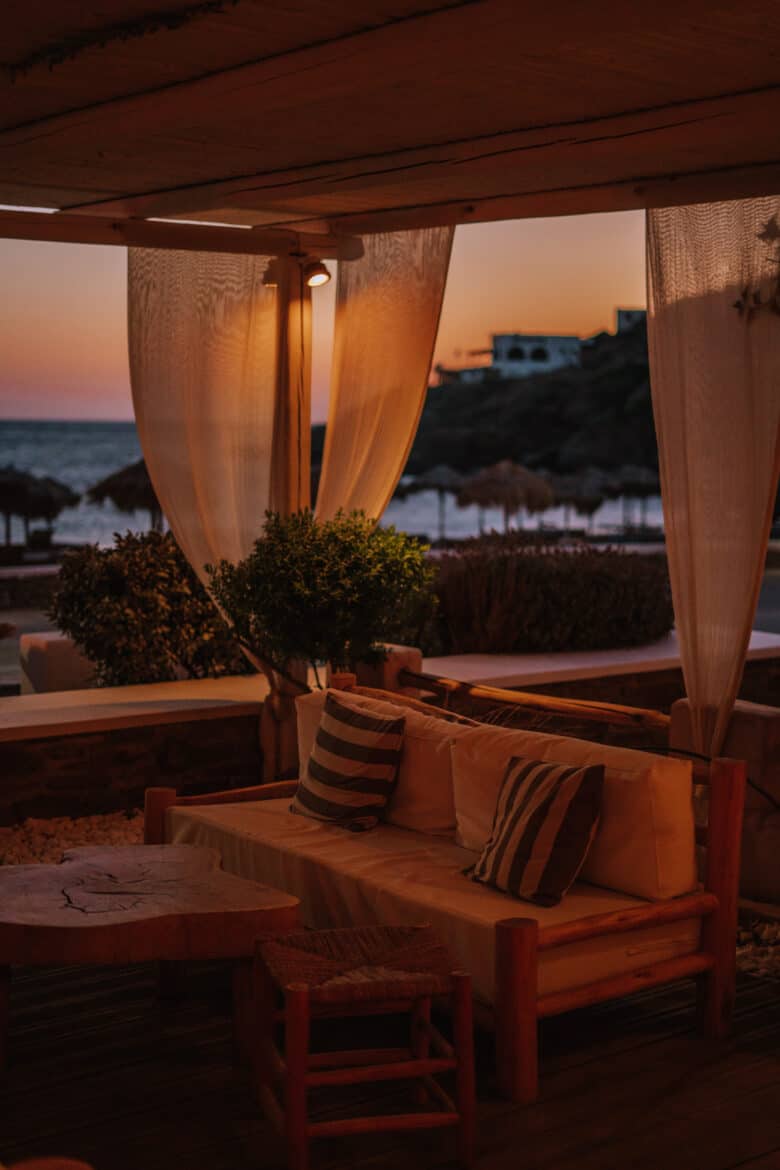 A patio on IOS Island with a table and chairs and a view of the ocean.