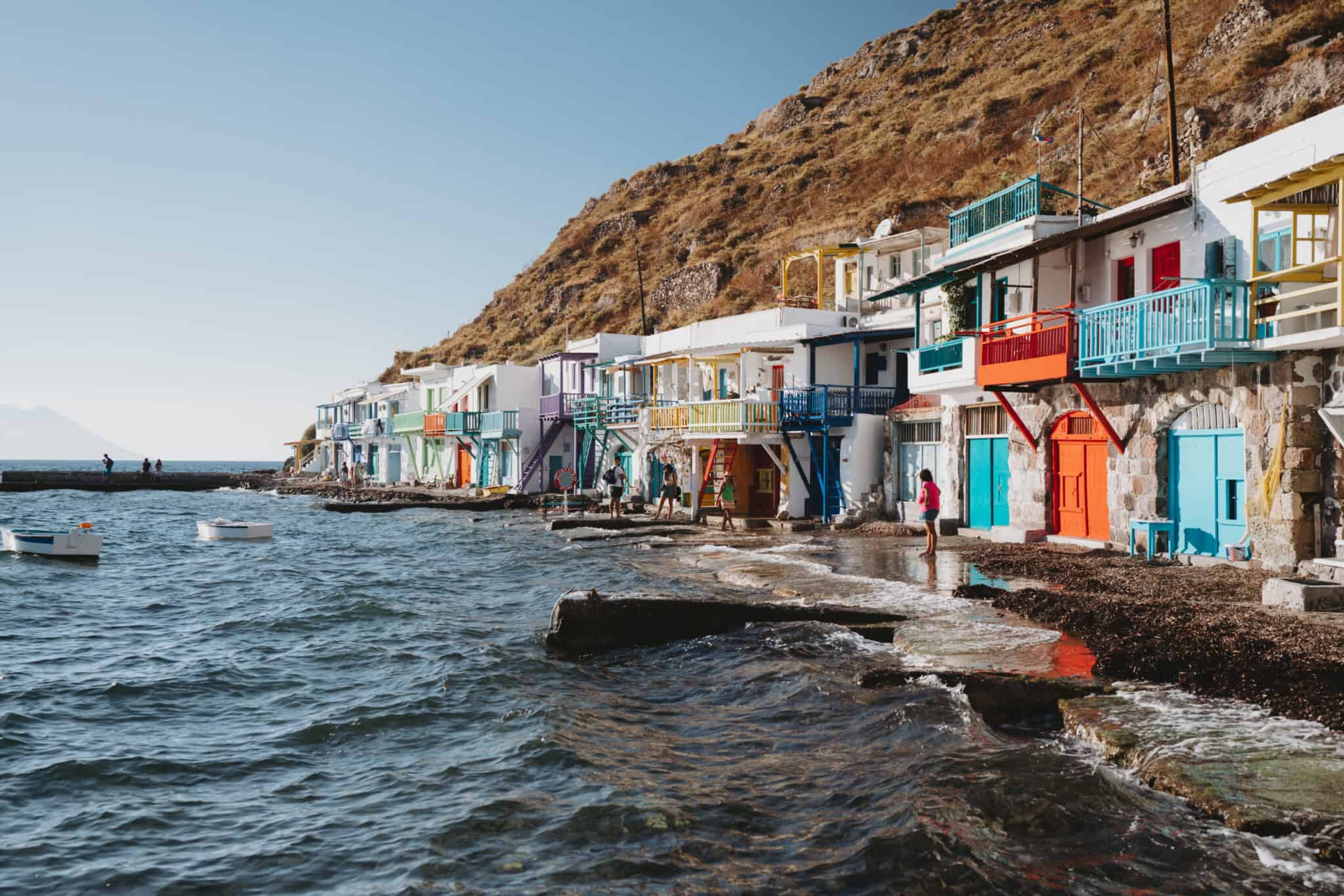 Colorful houses on a cliff near the water in Milos Greece.