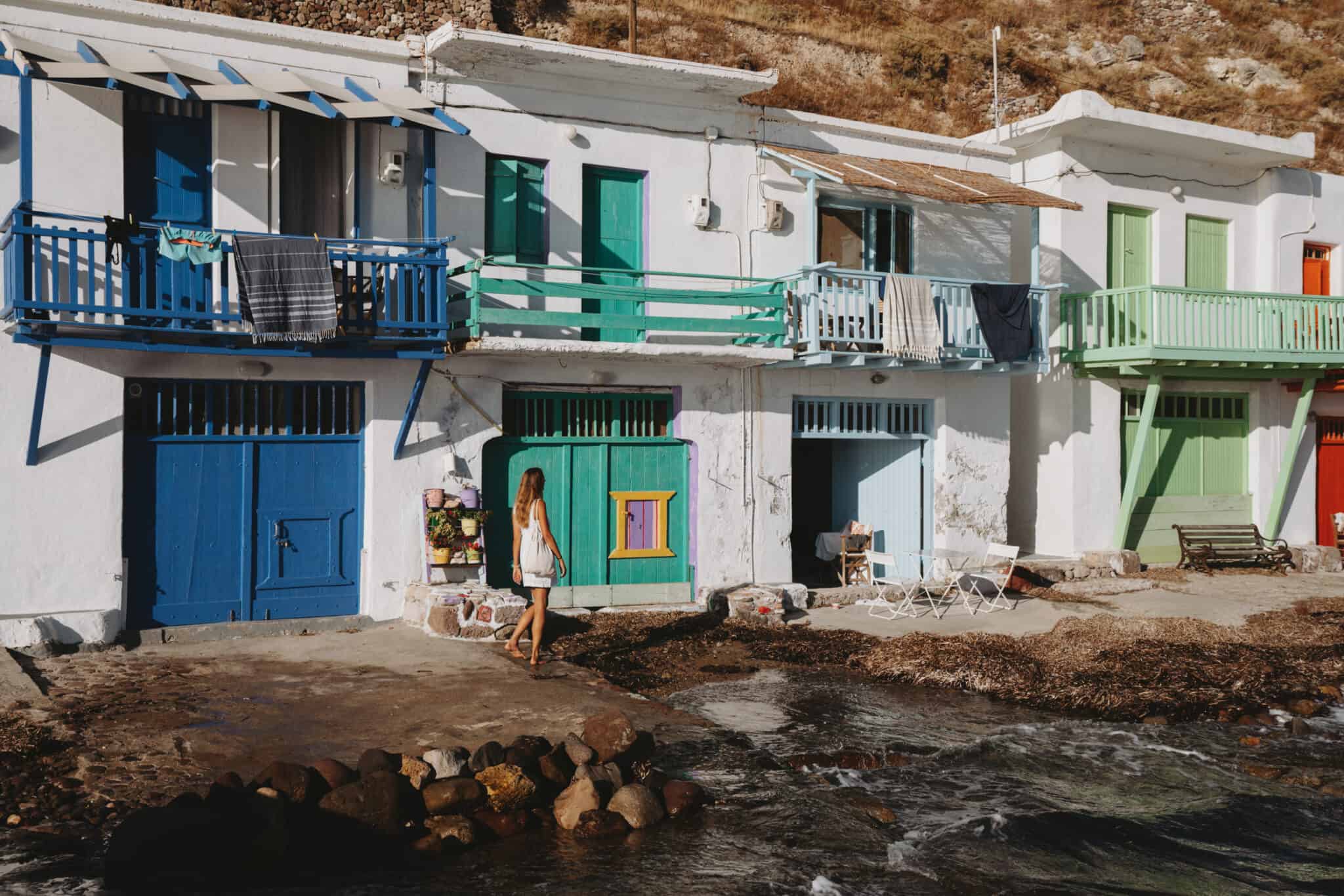 A row of colorful houses on a hillside in Milos Island.