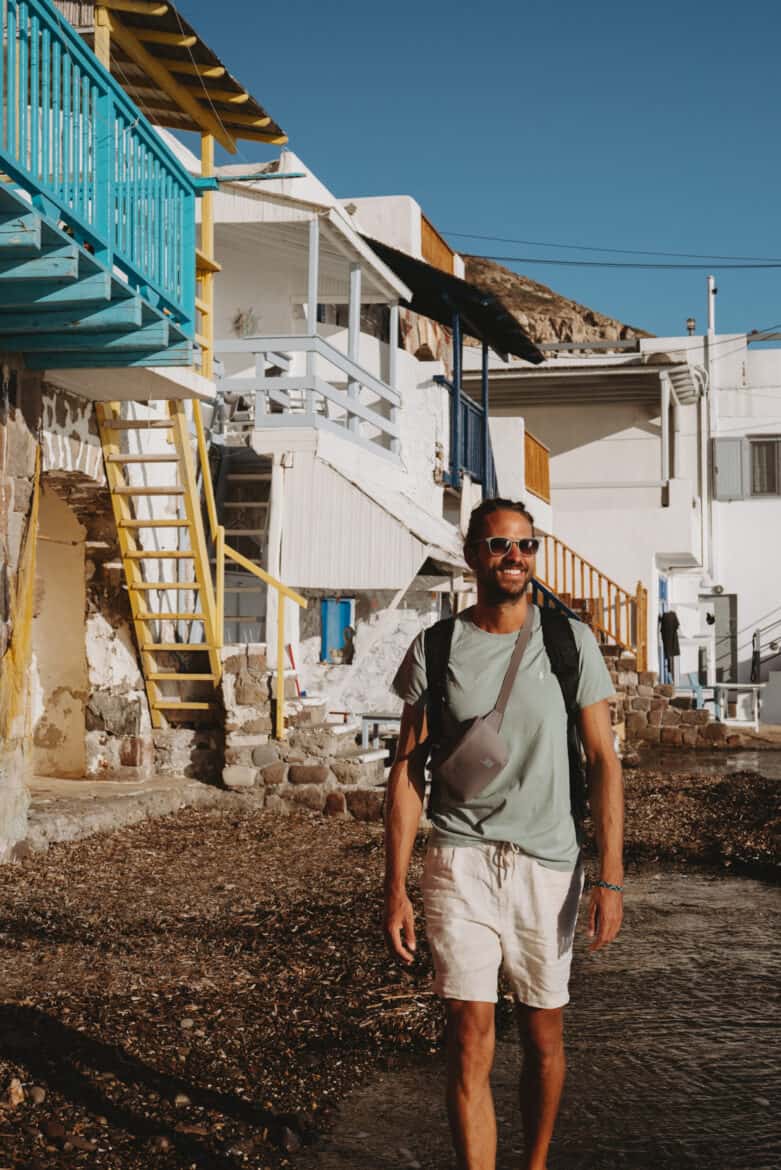 A man walking in front of a building in Mykonos, Greece.
