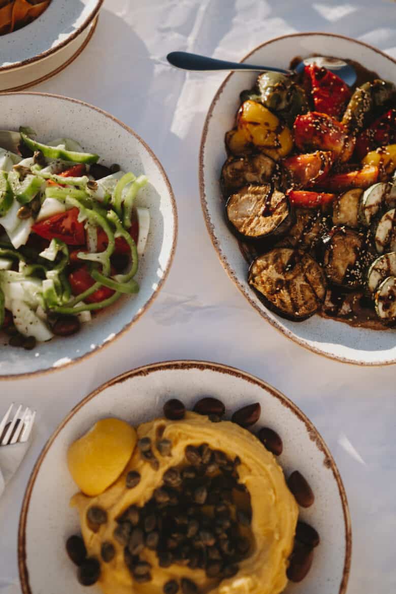 Four plates of food on a table in Milos, Greece.