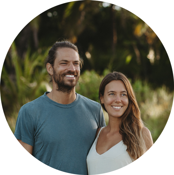 A man and woman smiling in front of a tree.