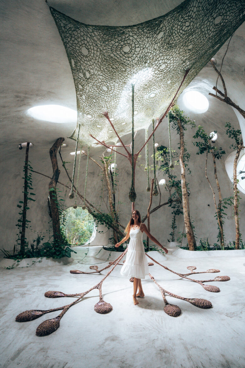 A woman in a white dress standing in a tree house.