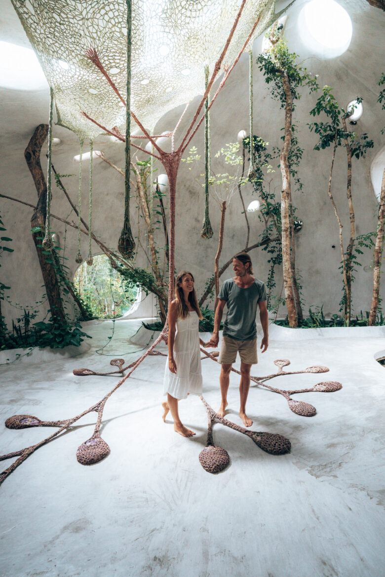 A couple standing in the middle of a tree house.